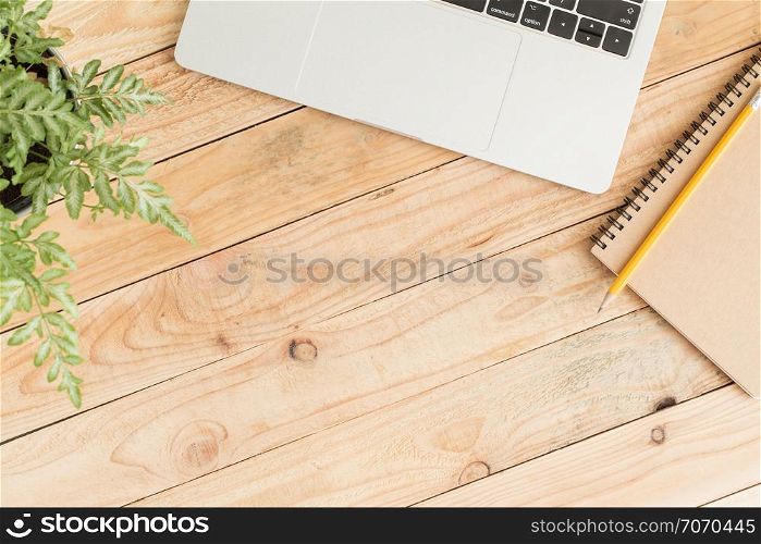 Flat lay photo of laptop and notebook on wood and copy space