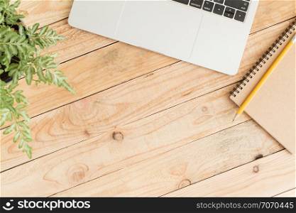Flat lay photo of laptop and notebook on wood and copy space