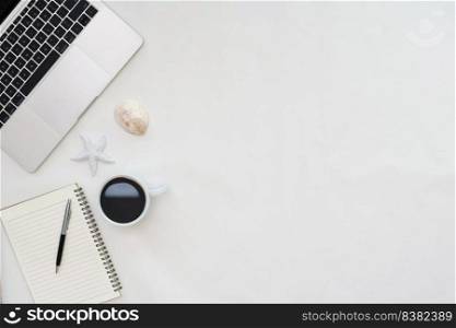 Flat lay photo of office desk with laptop, notebook, pen, coffee, starfish and shells with copy space background