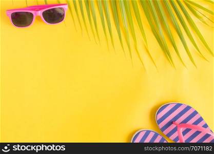 Flat lay photo sunglasses and sandals on yellow background , top view and copy space, summer concept