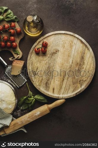 flat lay pizza dough with wooden board tomatoes