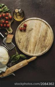 flat lay pizza dough with wooden board tomatoes