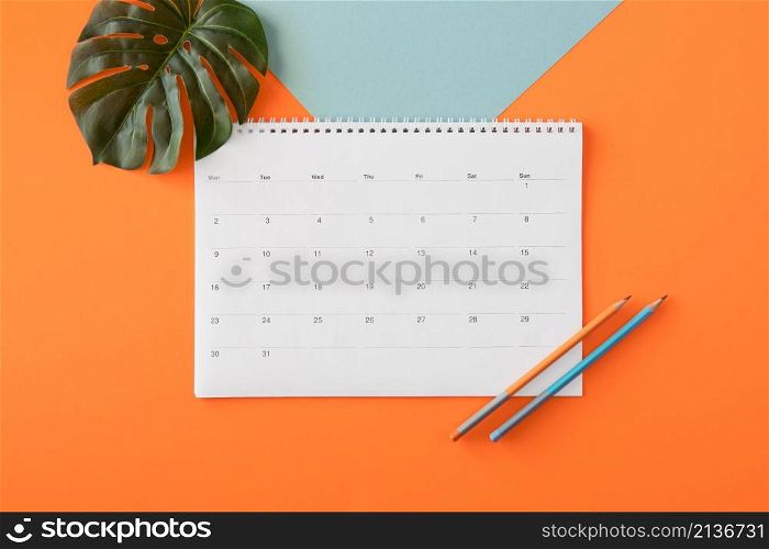 flat lay planner calendar with monstera leaf