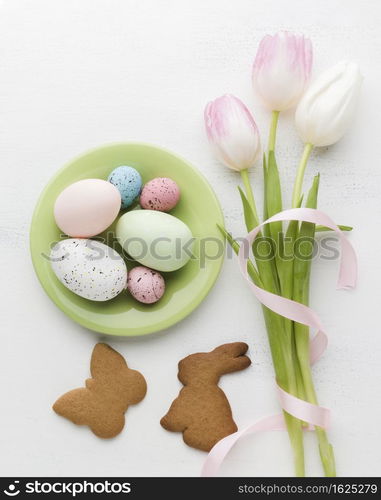 flat lay plate with colorful easter eggs cookies