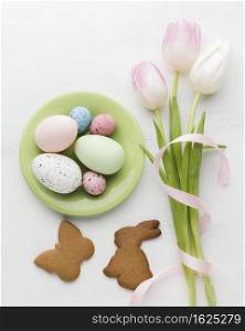 flat lay plate with colorful easter eggs cookies