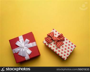 Flat lay red and white gift boxes with bows on yellow background. Red and white gift box with on yellow background,flat lay