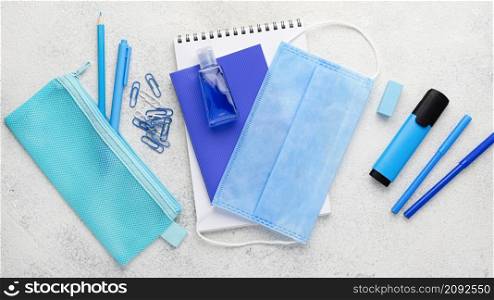 flat lay school essentials with notebook medical mask