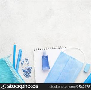 flat lay school essentials with paper clips medical mask