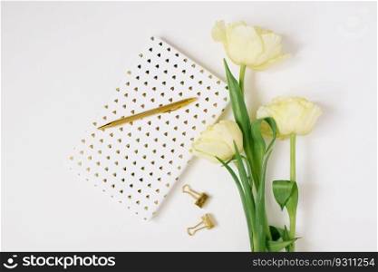 Flat lay Spring flowers Yellow tulips, cup of coffee white blank album notebook writing pen on white background. Lovely greeting card for March 8 Mothers day holiday birthday. Woman working desk