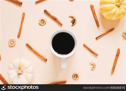 Flat lay style of autumn and thanksgiving concept with coffee, pumpkins and cinnamon sticks on pastel color, top view