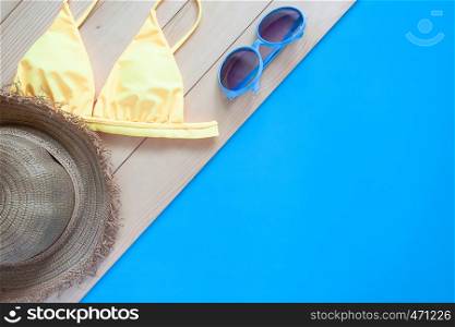 Flat lay summer items on wooden floor and blue colour background. Summer holiday
