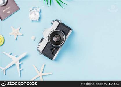 Flat lay top view mockup retro camera films, airplane, passport, starfish, shells traveler tropical accessories on a blue background with copy space, Vacation summer travel and business trip concept