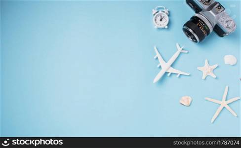 Flat lay top view mockup retro camera films, airplane, starfish, shells traveler tropical accessories isolated on a blue background with copy space, Business trip, and vacation summer travel concept