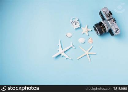 Flat lay top view mockup retro camera films, airplane, starfish, shells traveler tropical accessories isolated on a blue background with copy space, Business trip, and vacation summer travel concept