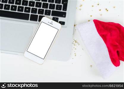 Flat lay, top view office table desk. Christmas workspace with laptop and phone on white background, copy space on blank screen. Christmas mock up