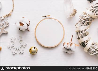 Flat lay top view photo of a mockup with an embroidery hoop and Christmas de. Stylish feminine new year layout composition.. Flat lay top view Christmas photo with an embroidery hoop and cute decoration.