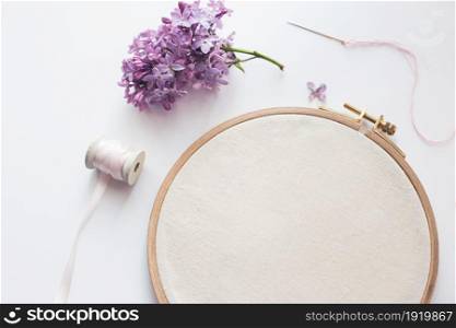 Flat lay top view photo of a mockup with embroidery hoop and flilac flowers. Stylish feminine floral mock-up.. Flat lay top view photo of a mockup with embroidery hoop and llilac flowers.
