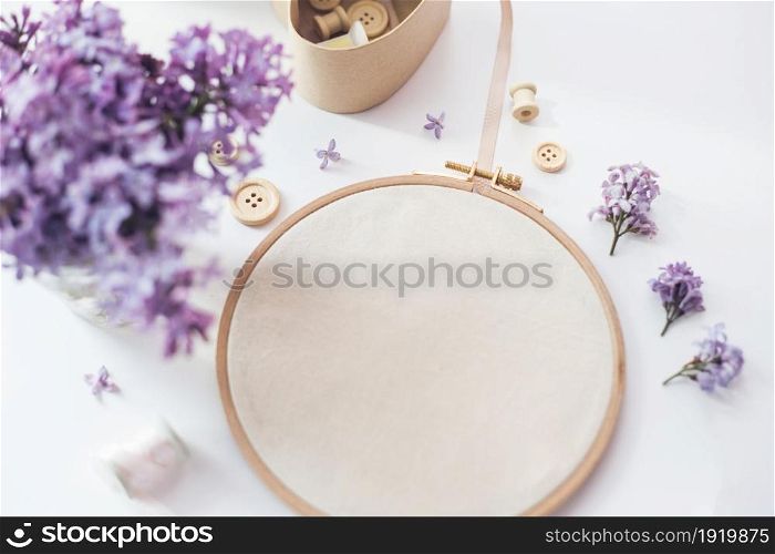 Flat lay top view photo of a mockup with embroidery hoop and flilac flowers. Stylish feminine floral mock-up.. Flat lay top view photo of a mockup with embroidery hoop and llilac flowers.