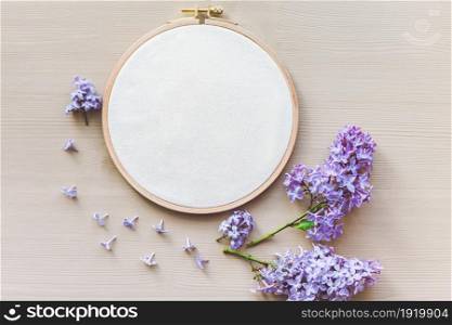 Flat lay top view photo of a mockup with embroidery hoop and flilac flowers. Stylish feminine floral mock-up.. Flat lay top view photo of a mockup with embroidery hoop and flilac flowers.