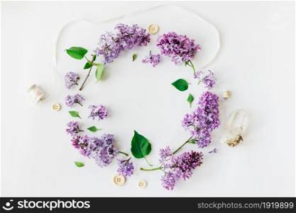 Flat lay top view photo of spring composition. Wreath made of lilac flowers on white background. Summery floral frame.. Wreath made of lilac flowers on white background.