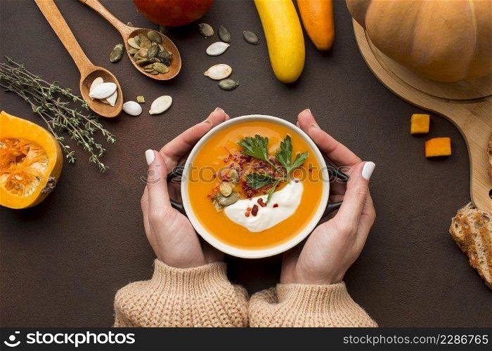 flat lay winter squash soup bowl held by hands