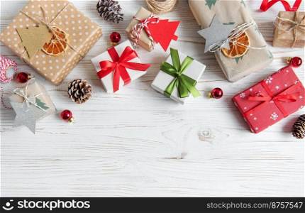 Flat lay with christmas gift boxes on white wooden background with decorations