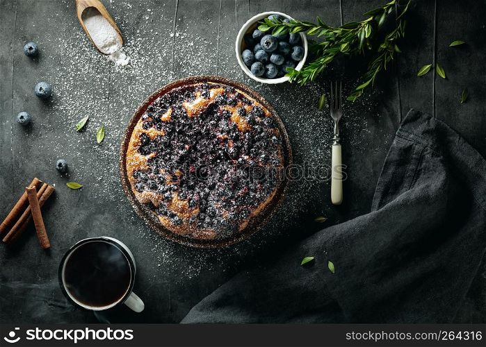 Flat lay with delicious homemade blueberry pie on dark background