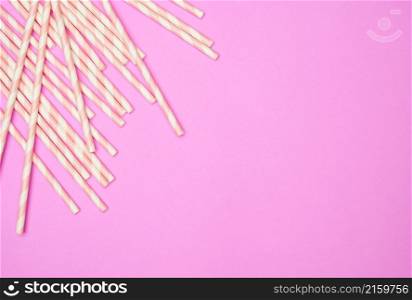 Flat lay with striped drink straws on pink background.. Flat lay with striped drink straws on pink background