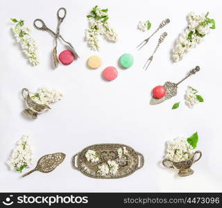 Flat lay with white lilac flowers and macaroon cakes. Sweet food background