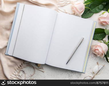 Flat lay women’s office desk. Female workspace with pink rose flower bouquet, dairy, glasses 