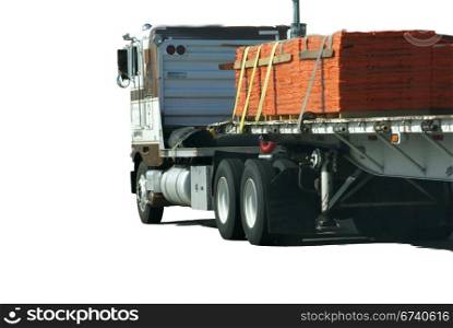 Flatbed semi truck with cargo, speeding down highway
