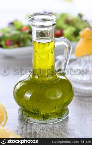 Flavored fresh natural olive oil with herbs and garlic in a glass sauce boat bottle, an ideal salad dressing.
