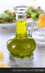 Flavored fresh natural olive oil with herbs and garlic in a glass sauce boat bottle, an ideal salad dressing.