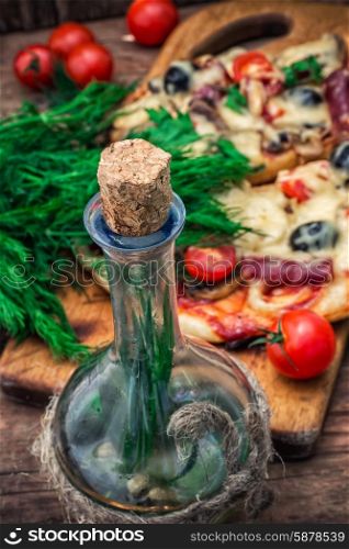 flavorful homemade pizza with bacon. delicious meat pizza with bacon and olives on bottles of olive oil.The image is tinted