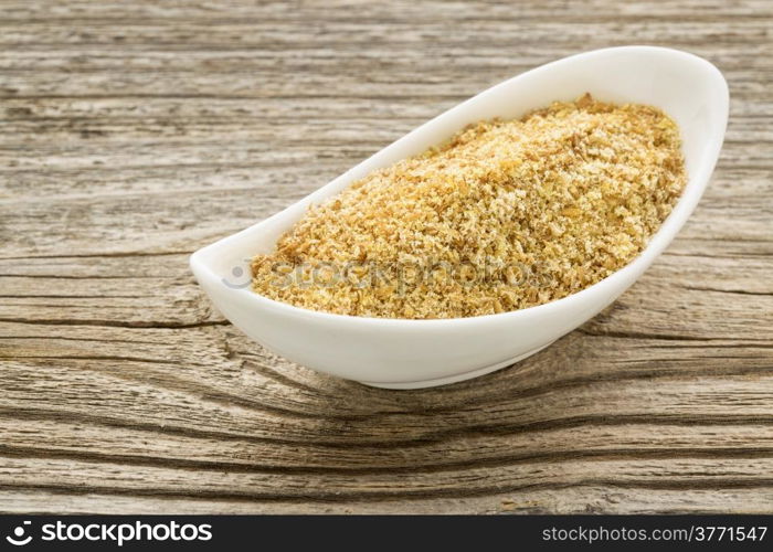 flax seed meal in a small ceramic bowl against grained wood