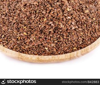 Flax seeds in a wooden plate isolated on a white background