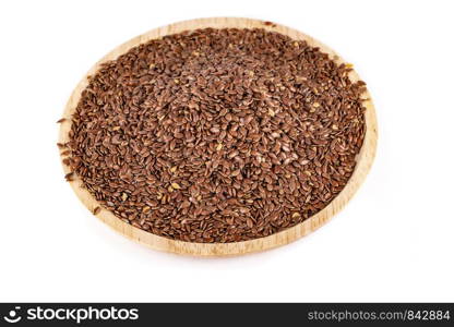 Flax seeds in a wooden plate isolated on a white background