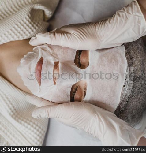 flay lay young woman getting skin mask treatment