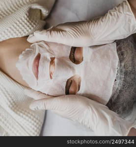 flay lay young woman getting skin mask treatment