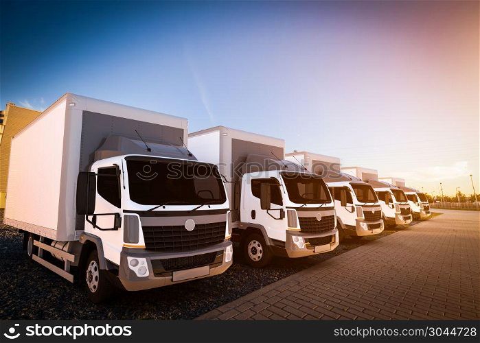 Fleet of commercial delivery trucks on cargo parking. Generic, brandless vehicle design. 3D rendering. Fleet of commercial delivery trucks on cargo parking