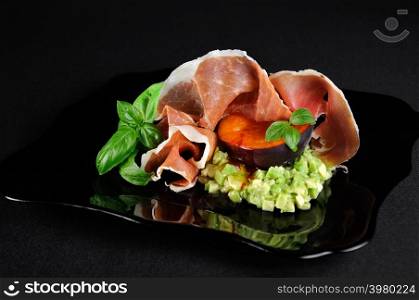Flesh avocado with a slice of black apricots with spicy hot and sweet sauce and Parma ham.