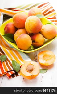 Fleshy apricots in the bowl on the table