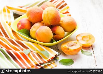 Fleshy apricots in the bowl on the table. Apricots