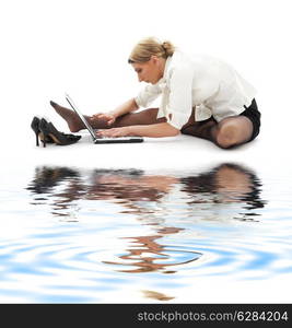 flexible businesswoman with laptop computer on white sand