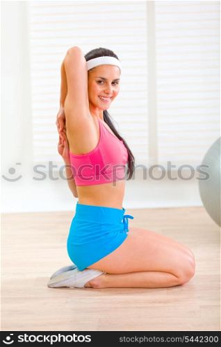 Flexible slim female doing gymnastics exercise at living room&#xA;