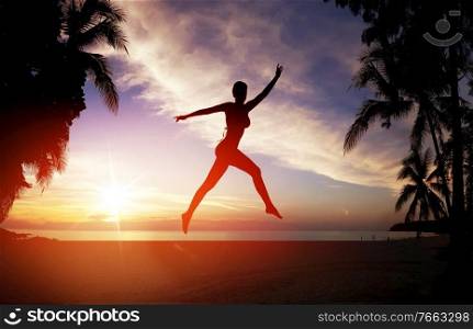 Flexible woman training on a tropical beach