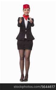 Flight attendant gesturing towards exits isolated over white background