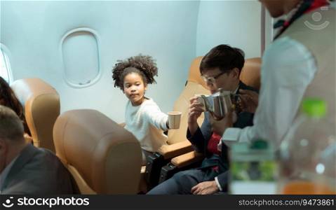 Flight attendant serving beverages to business class passengers