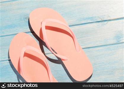 flip flops on table. pink flip flops on blue wooden table with sunlight