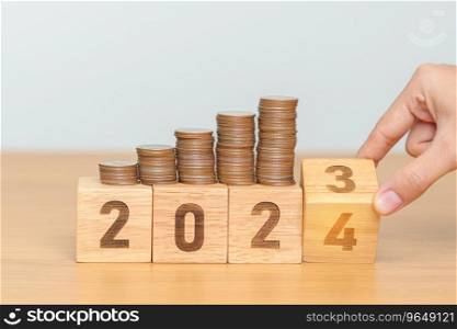 flipping 2023 to 2024 year block with Coins stack. Money, Budget, tax, investment, financial, savings and New Year Resolution concepts